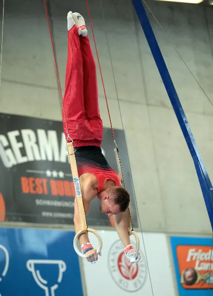 Bombensicher steht Christian Bammer im Handstand an den Ringen