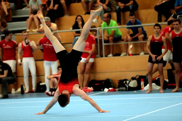 Mit Kraft fixiert Markus Schmid den Schweizer Handstand in seiner Bodenübung.
